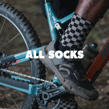 Close-up of a mountain bike with a person wearing checkered socks, text 'ALL SOCKS' overlayed.