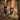 Person wearing black socks with a logo and green shoes on a forest floor next to a bike.