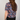 Person wearing a colorful floral patterned shirt on a plain background