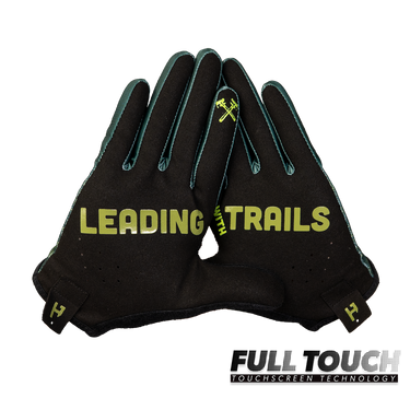 A pair of black touchscreen racing gloves with green accents and yellow 'LEADING TRAILS' branding, displayed against a solid white background with a 'FULL TOUCH TOUCHSCREEN TECHNOLOGY' logo overlay in the bottom right corner.