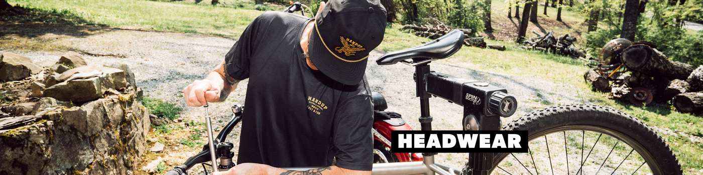 Person adjusting a bicycle with 'Headwear' text overlay