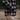 person wearing a plaid flannel jacket and khaki pants outdoors with a blurred background.