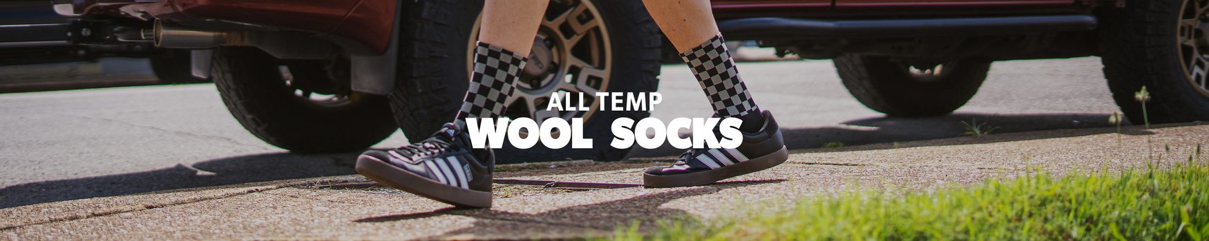 Person wearing checkered socks with text 'All Temp Wool Socks' on a blurred street background