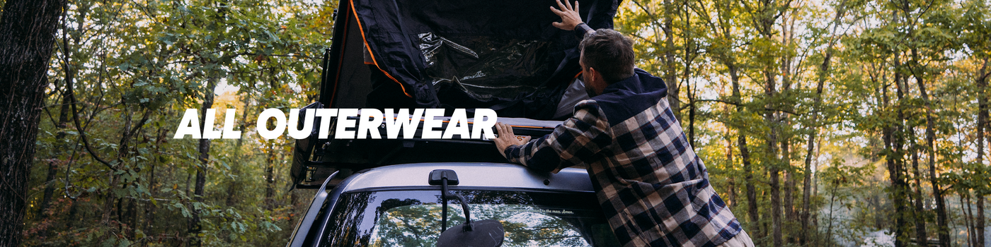 Person setting up a rooftop tent in a forest with 'All Outerwear' text overlay.