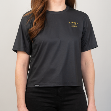 Person wearing a black t-shirt with yellow text on a plain background