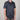 Person wearing a navy blue short-sleeve shirt with a pattern on a plain background