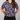 Person wearing a colorful floral patterned shirt on a plain background